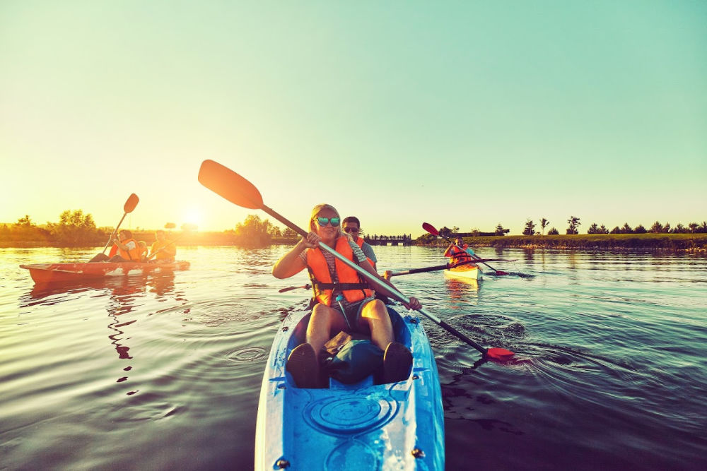 Three kayaks in the water at sunset